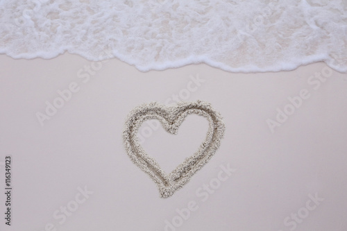 wave on a sand with heart drawing