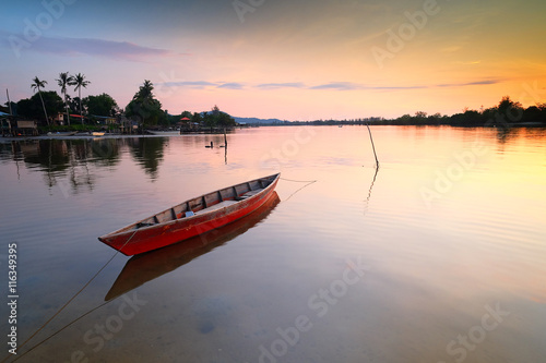 Boat anchored on the beach at sunset, Tuaran, Sabah, Malaysia photo