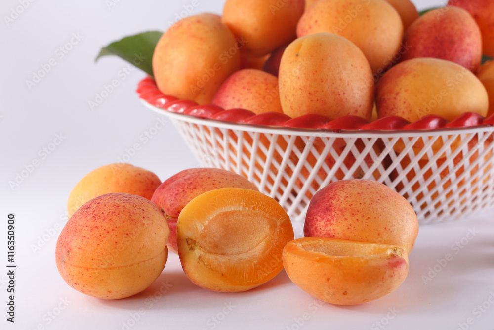 Cut apricot on background heap of apricots in a bowl