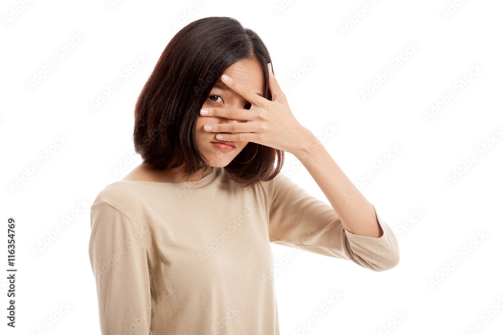 Beautiful young Asian woman peeking through fingers isolated on white background Beautiful young Asian woman peeking through fingers isolated on white background