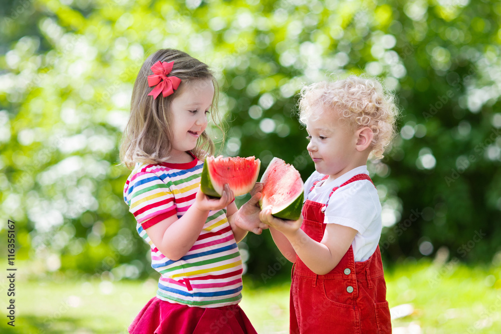Fototapeta premium Kids eating watermelon in the garden