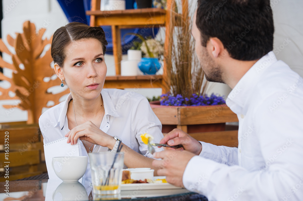 Successful manager sitting at business lunch with colleague and giving instructions to her Successful manager sitting at business lunch with colleague and giving instructions to her