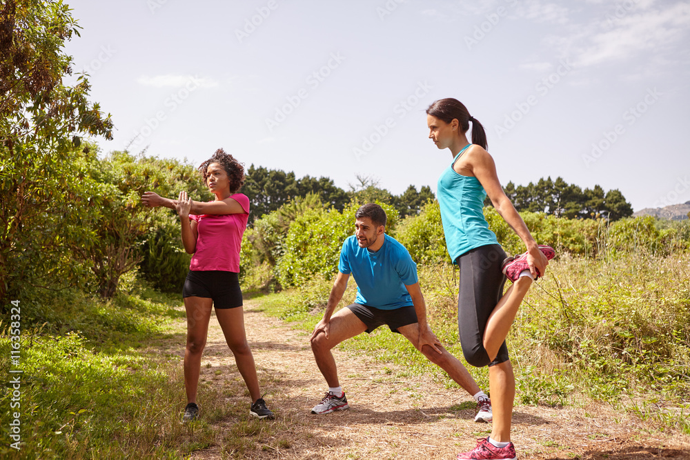 Fototapeta premium Stretching joggers on a running trail