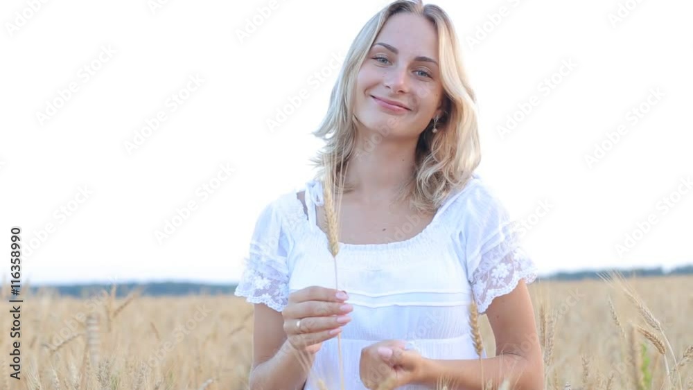 Female hand touching a golden wheat ear in the wheat field Female hand touching a golden wheat ear in the wheat field