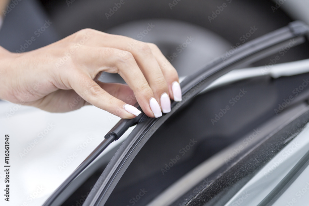 The wipers on the glass car regulates the hand of the girl. The wipers on the glass car regulates the hand of the girl.