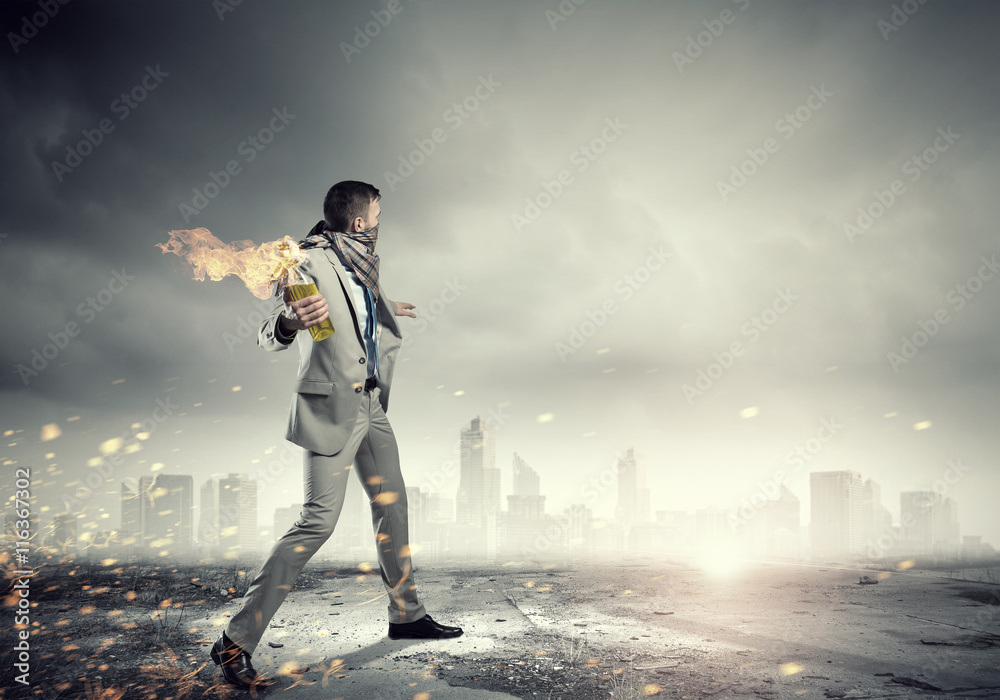 Businessman throwing petrol bomb . Mixed media Businessman throwing petrol bomb . Mixed media