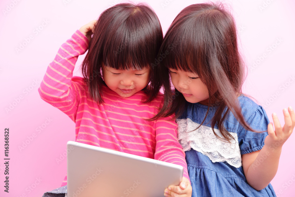 two little girls watching tablet two little girls watching tablet