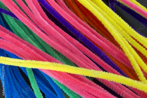 This is a photograph of Blue,Green,Purple,Orange,Pink and Yellow pipe cleaners background