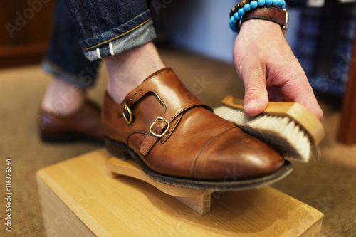 Man polishing leather double monk strap shoe photo