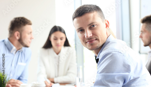 Businessman with colleagues in the background in office