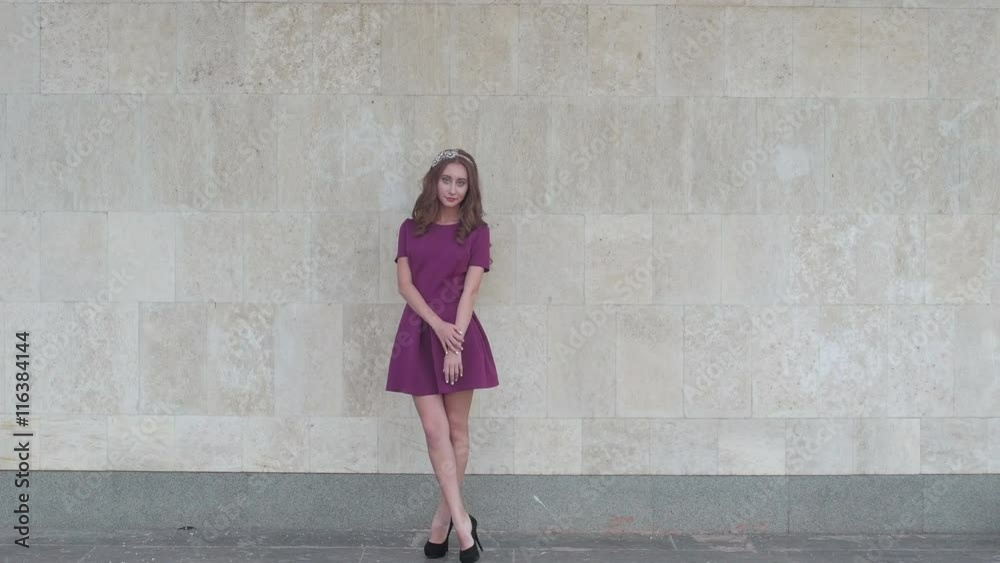 Young attractive woman posing near wall for fashion photographer Young attractive woman posing near wall for fashion photographer