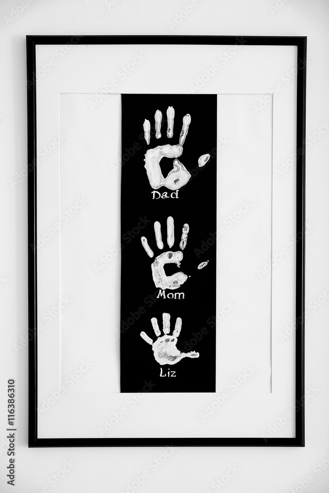 Fototapeta premium Family handprint art in black frame, personalized keepsake for parents and child, home decor and sentimental gift