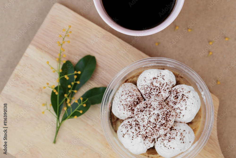 Banoffee cake in cup and black coffee, top view on wooden plate. Banoffee cake in cup and black coffee, top view on wooden plate.