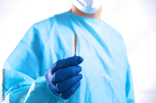 Young surgeon holding a scalpel. Ready for operation