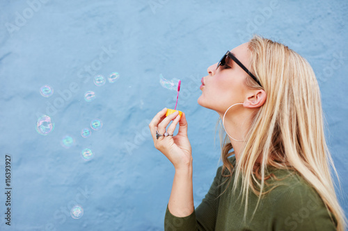 Canvas-taulu Attractive female blowing soap bubbles
