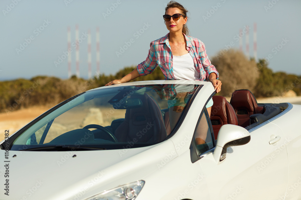 Naklejka premium Beautiful woman sitting in cabriolet, enjoying trip on luxury mo