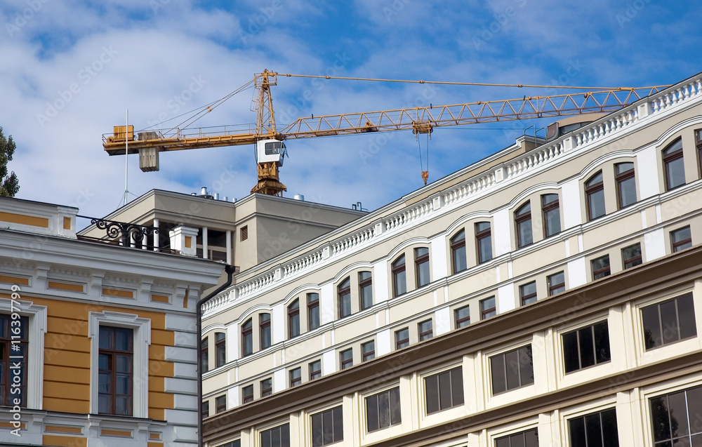 Building crane on the background of city buildings