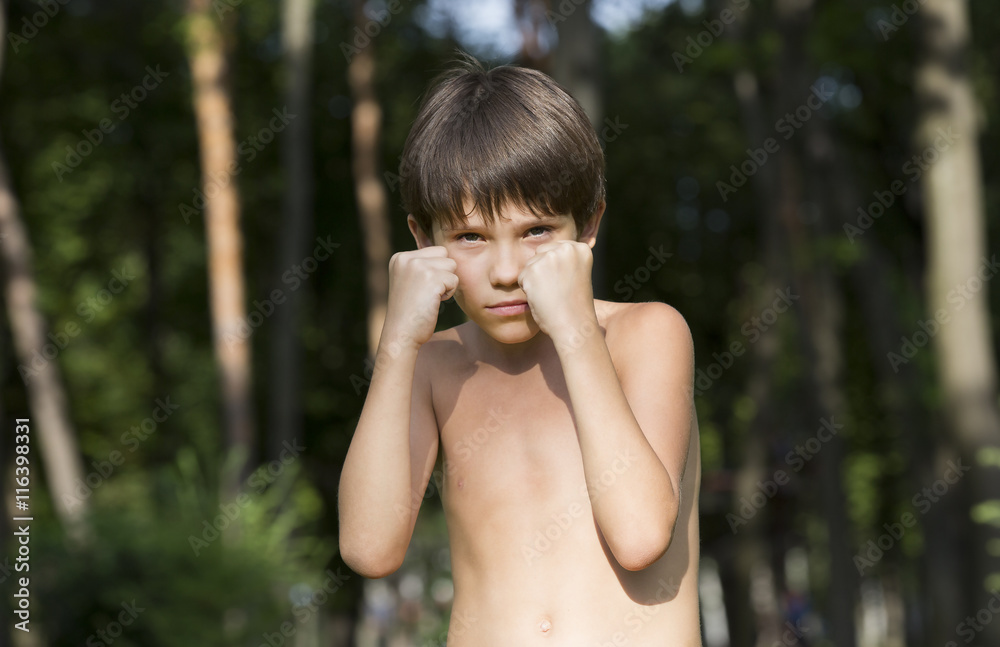 Fototapeta premium portrait of a boy in nature which shows his muscles