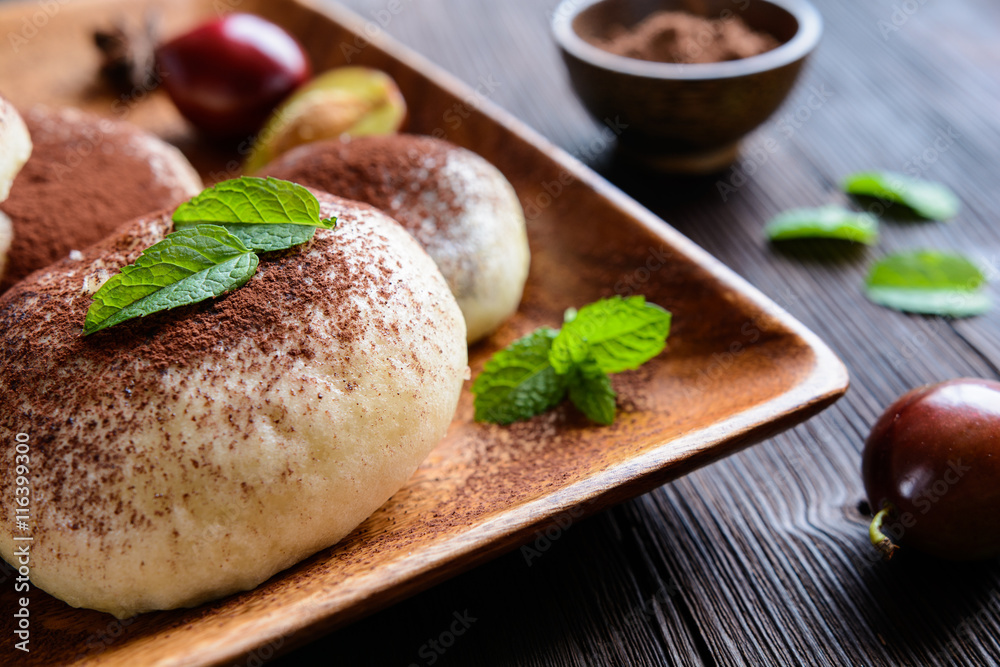 Sweet steamed dumplings with a plum jam, sprinkled with cocoa powder