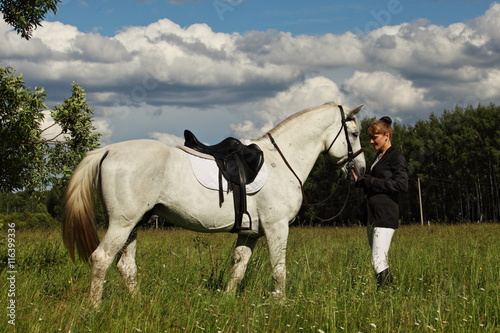 Beauty fashion model in equestrian hunt uniform posing with horse © horsemen