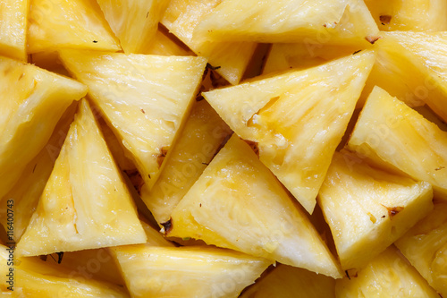 Background of freshly cut pineapple pieces from above.