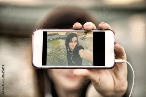 Young woman taking a photo with her phone