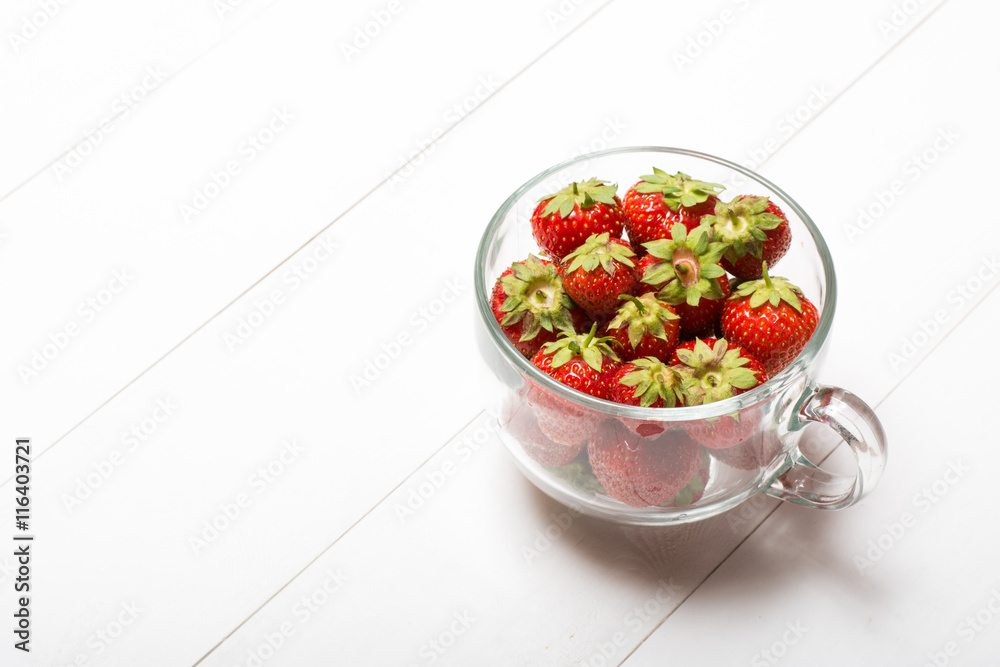 Glass cup full of strawberries on table Glass cup full of strawberries on table