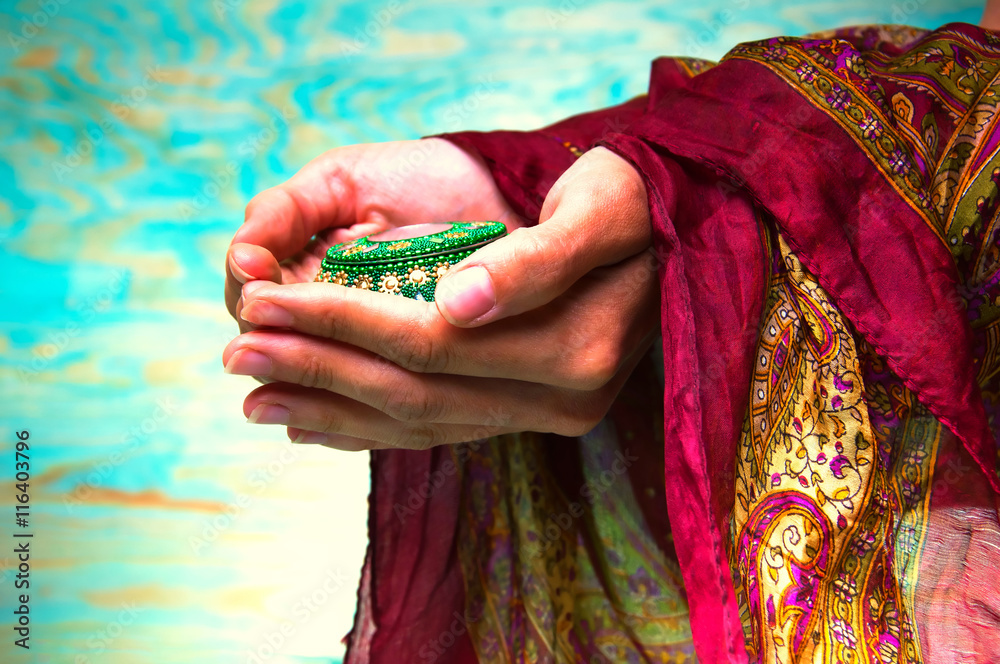 Woman's hands holding green oriental casket Woman's hands holding green oriental casket