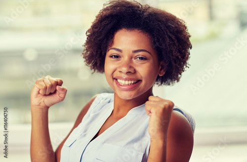 happy african young woman with raised fists