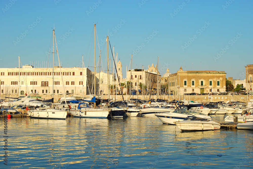 Boats moored in the Port of Trani in Apulia at sunset - Italy