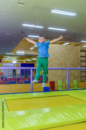 Happy little boy bouncing on a trampoline