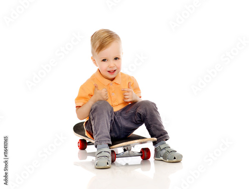 happy little boy on skateboard showing thumbs up