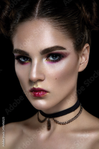 Beautiful woman portrait with glamour make up and jewelry on neck on black background.