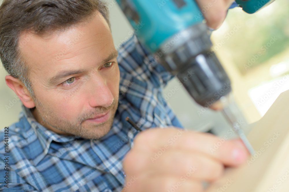 Naklejka premium Carpenter carefully drilling a hole