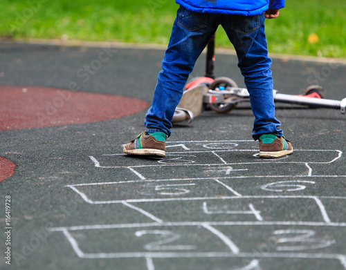 kid playing hopscotch on playground outdoors
