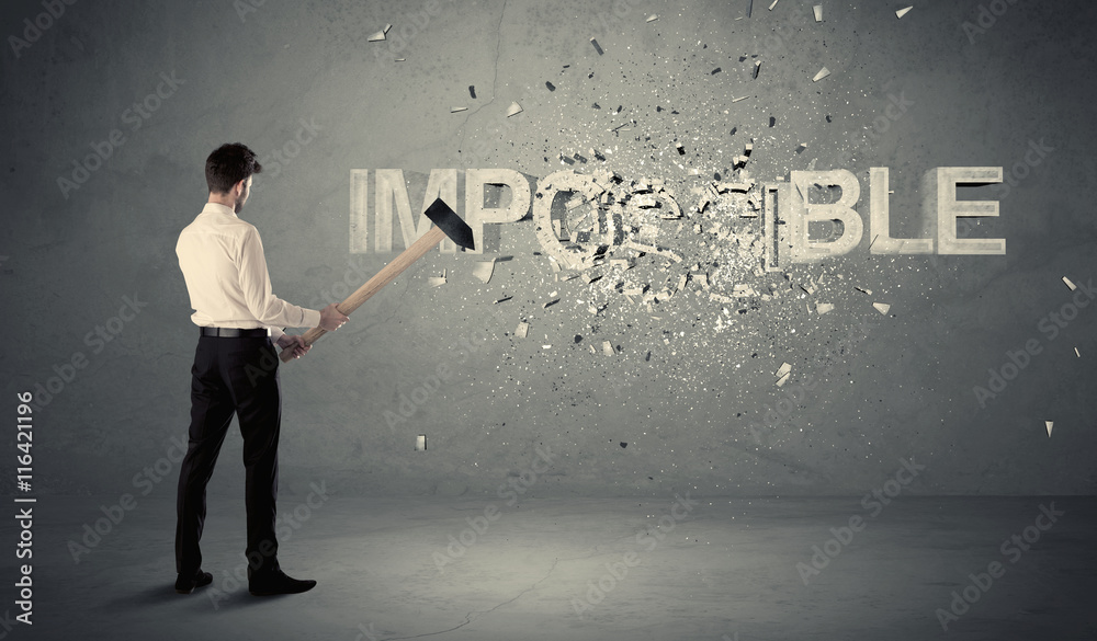Business man hitting impossible sign with hammer Business man hitting impossible sign with hammer