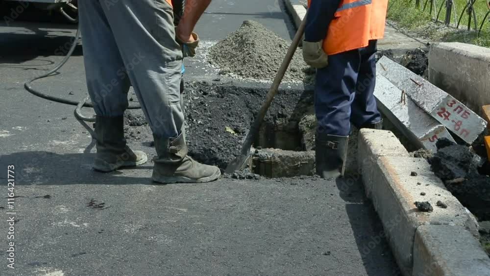 Road Paving. Workers laying stone mastic asphalt during street repairing works. Worker making asphalt with coated chippings. Drainage repair, installation of manhole Road Paving. Workers laying stone mastic asphalt during street repairing works. Worker making asphalt with coated chippings. Drainage repair, installation of manhole
