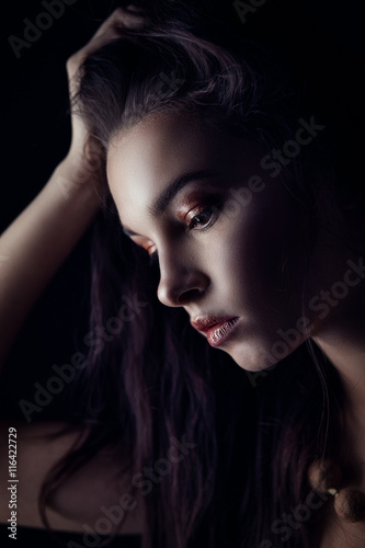 Low key beauty portrait of brunette in profile