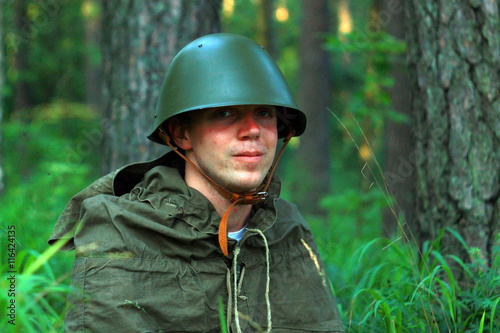 Военный солдат разведчик с биноклем в лесу