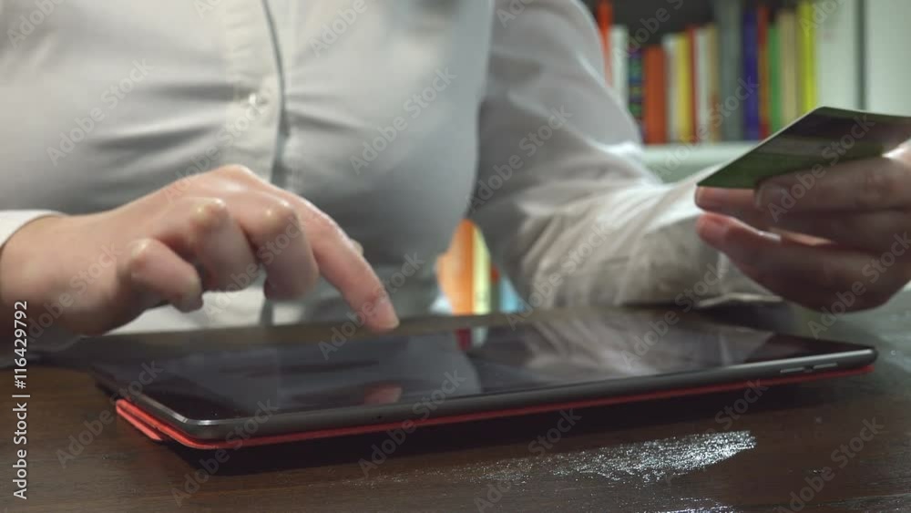 woman using tablet computer and credit card to make shopping online
woman using tablet computer and credit card to make shopping online