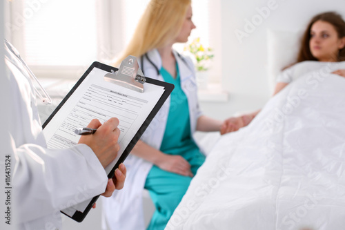 Close-up of a female doctor while filling up medical history record