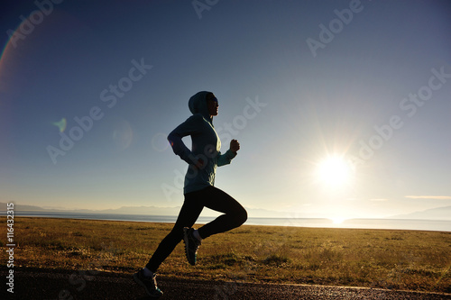 Fototapeta Naklejka Na Ścianę i Meble -  healthy young fitness woman runner running on sunrise seaside trail