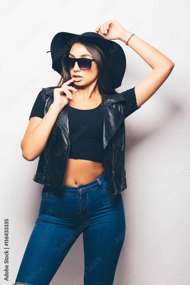 beautiful fashion girl wearing sunglasses and black hat over a white background.