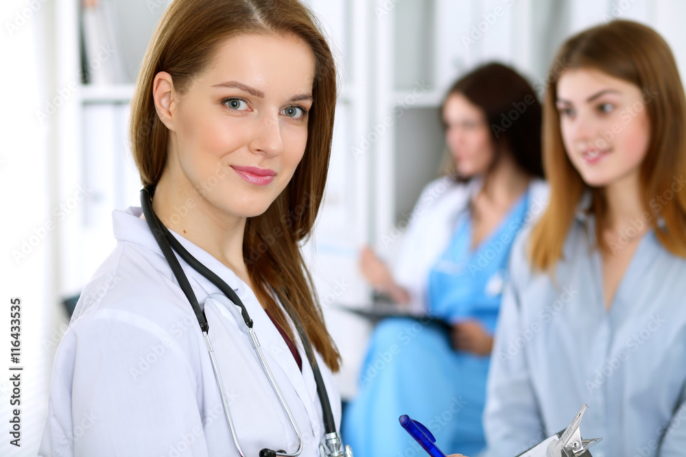 Young beautiful female doctor smiling to patient while consulting her. Young beautiful female doctor smiling to patient while consulting her.