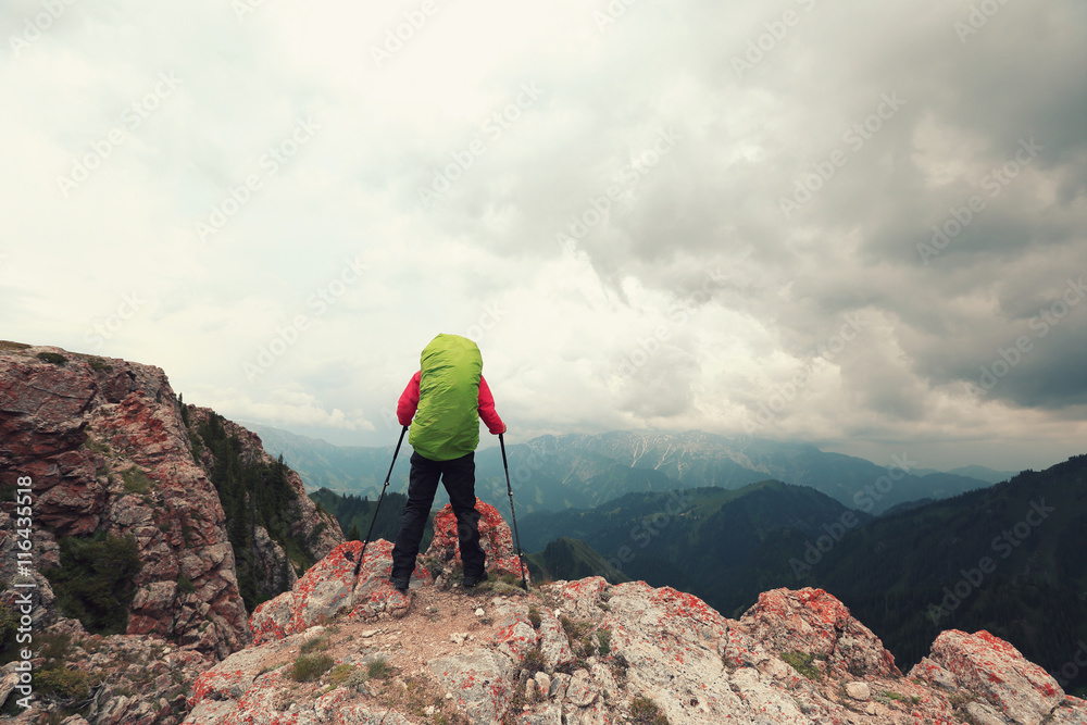 successful woman backpacke hiking  on mountain peak cliff