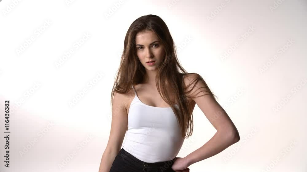 Girl with long dark hair looks to camera, serious expression Girl with long dark hair looks to camera, serious expression