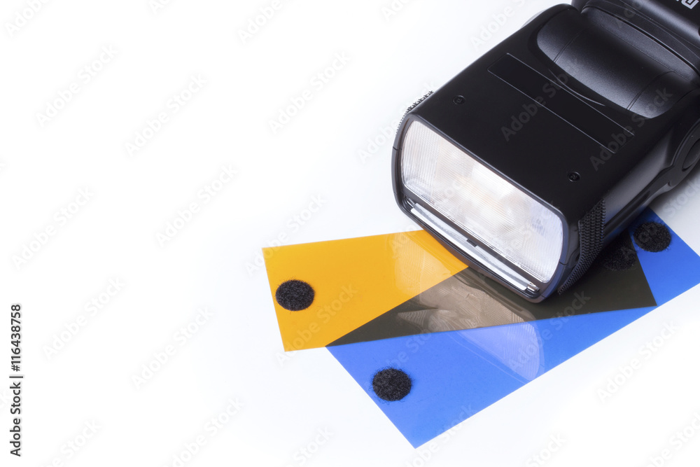 Head of a camera flash, over a white background with two gels, orange (CTO) and blue (CTB). Head of a camera flash, over a white background with two gels, orange (CTO) and blue (CTB).