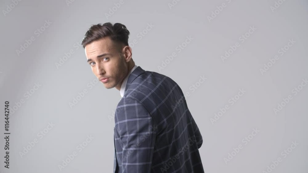 Young man in suit, back view, turns to face camera Young man in suit, back view, turns to face camera