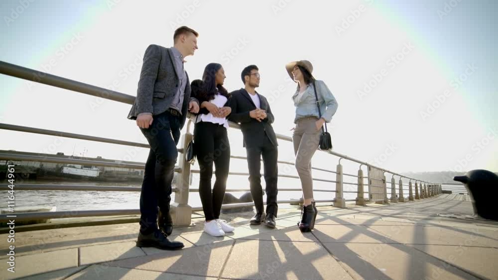 multi ethnic group of young professionals standing together talking about life multi ethnic group of young professionals standing together talking about life