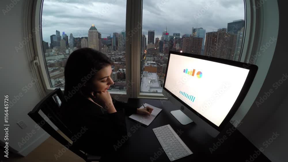 businesswomen working on computer desk in office at night analyzing charts